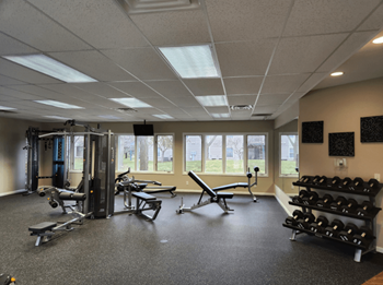 A spacious gym with a variety of equipment including weights and cardio machines.